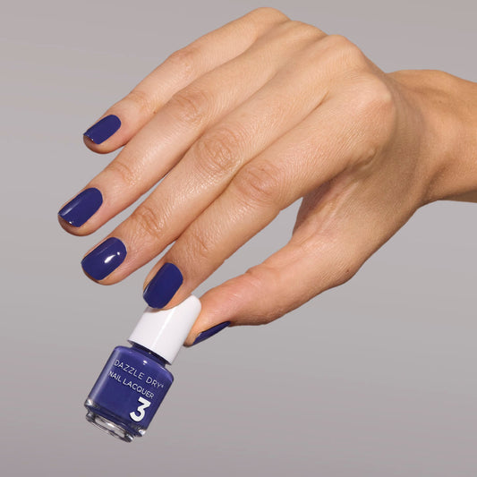 Hand with Base Camp painted on nails holding mini nail lacquer