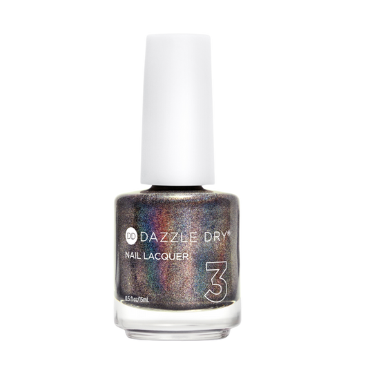 A bottle of Dazzle Dry Nail Lacquer in a shimmery, holographic metallic shade with silver, bronze, and purple tones, featuring a white cap on a plain white background.