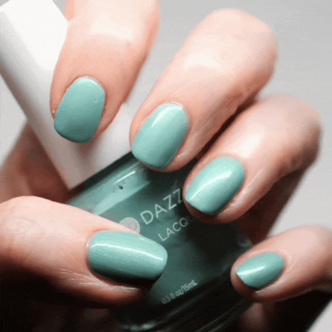 Hand with In Season painted on nails holding lacquer bottle