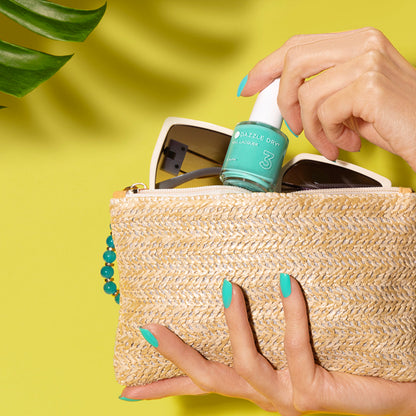 Hands with Coastal Cabana painted on nails holding a bag while putting a nail lacquer bottle inside of it