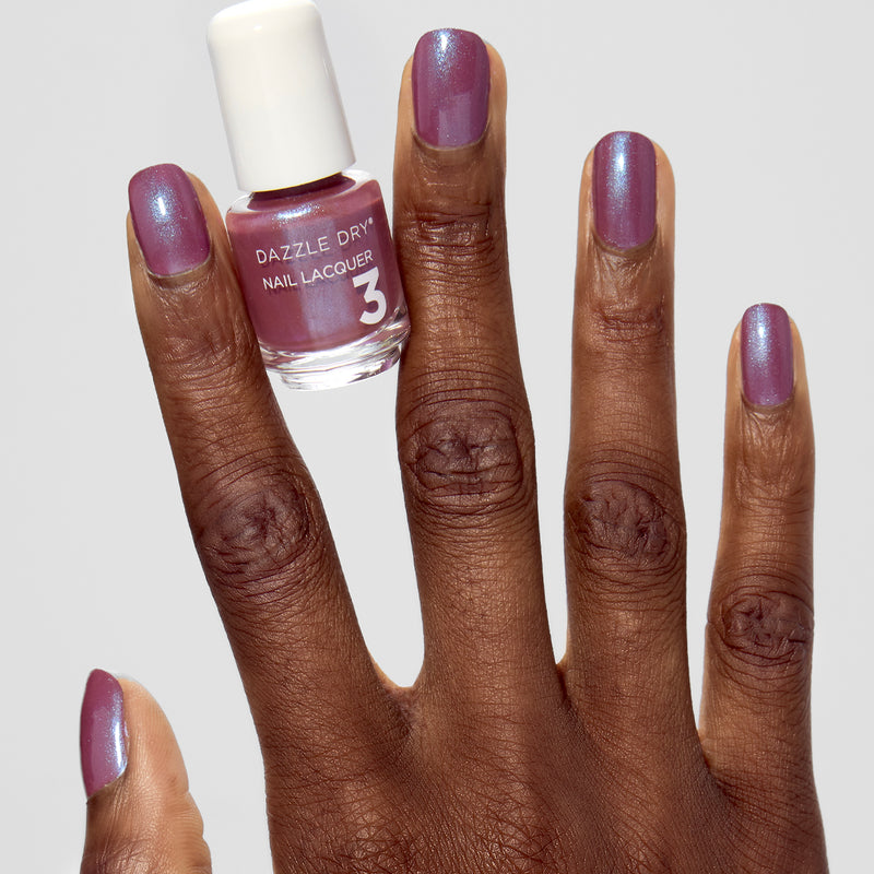 Hand with School Spirit painted on nails holding mini lacquer bottle