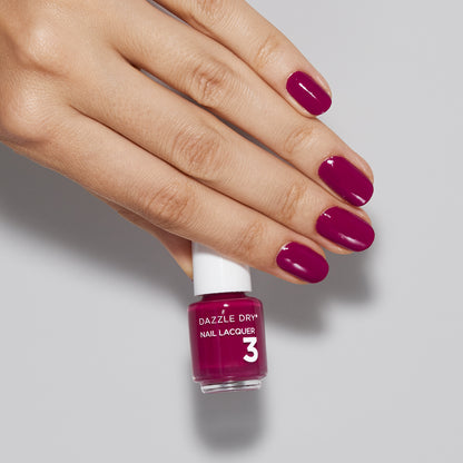 Hand with Raspberry Rush painted on nails holding mini lacquer botte