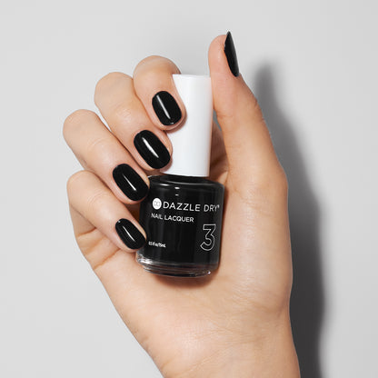 Hand with Midnight Express painted on nails holding lacquer bottle