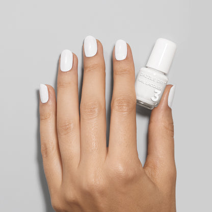 Hand with White Lightning painted on nails holding mini lacquer bottle