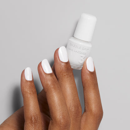 Hand with White Lightning painted on nails holding mini lacquer bottle