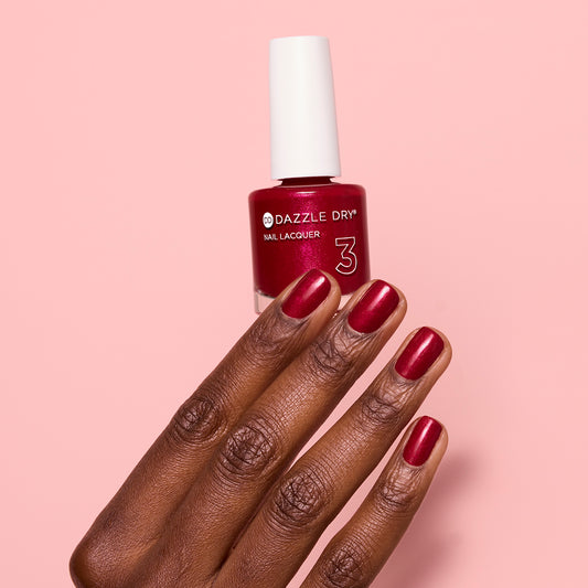 Hand with Apple Of My Eye painted on nails holding lacquer bottle