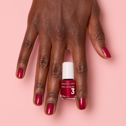 Hand with Apple Of My Eye painted on nails holding mini lacquer bottle