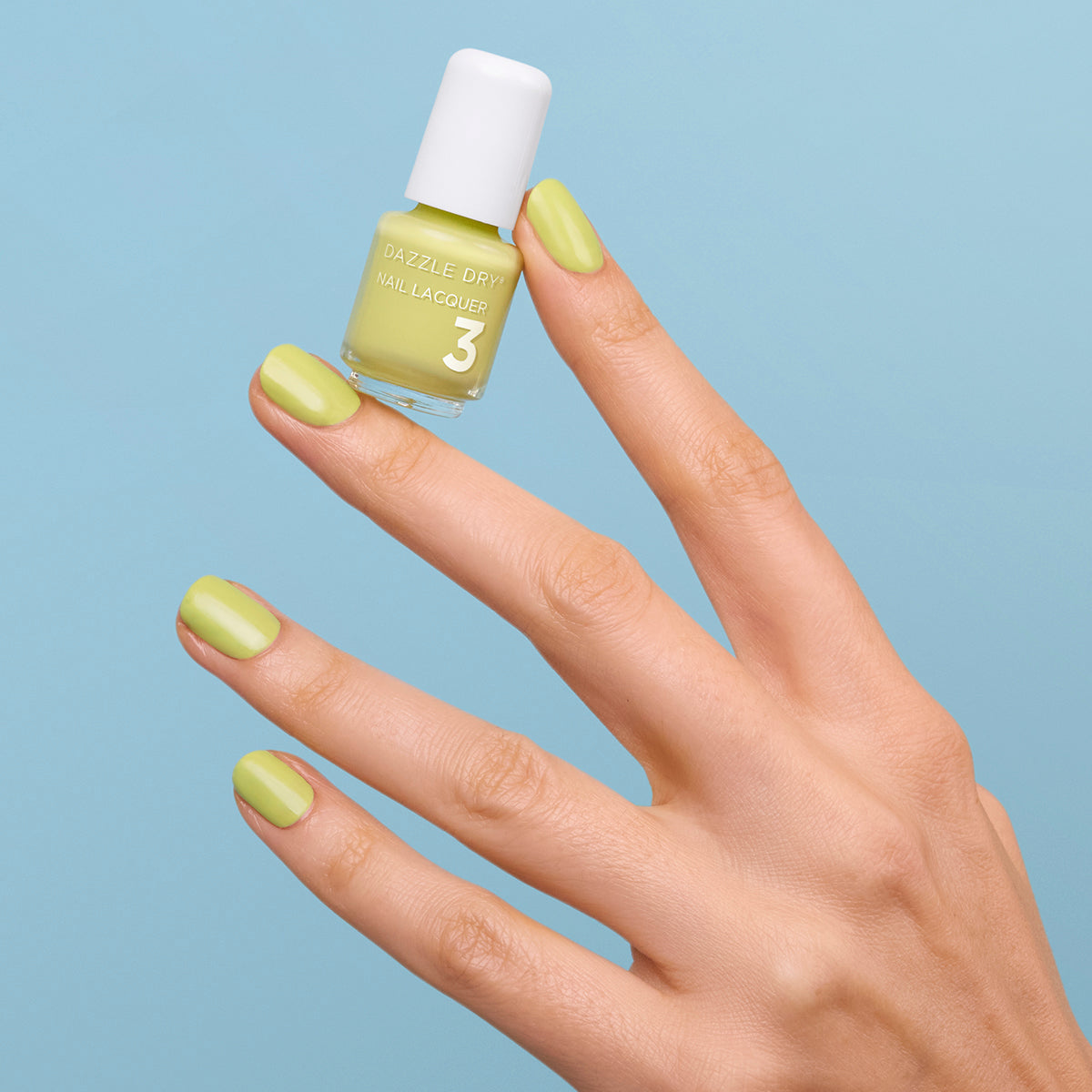 Hand with Fresh Squeezed painted on nails holding mini lacquer bottle