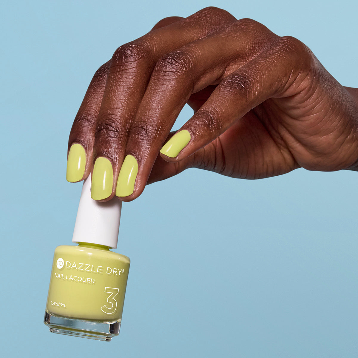 Hand with Fresh Squeezed painted on nails holding lacquer bottle