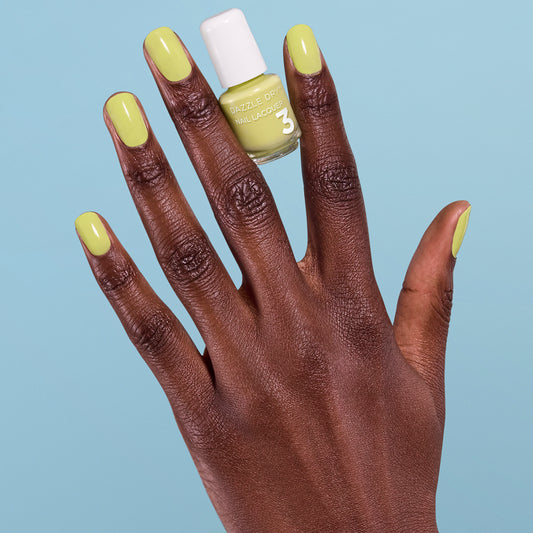 Hand with Fresh Squeezed painted on nails holding mini lacquer bottle