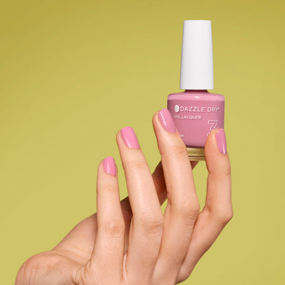 Hand with Picking Peonies painted on nails holding lacquer bottle