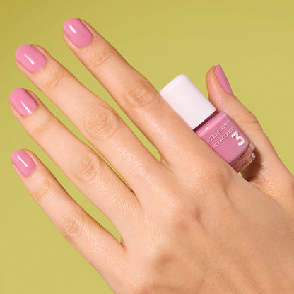 Hand with Picking Peonies painted on nails holding mini lacquer bottle