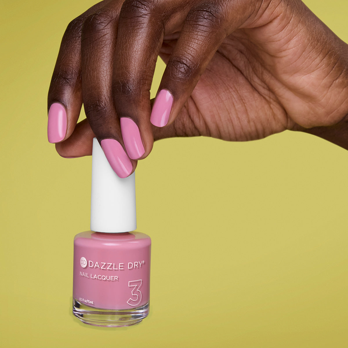 Hand with Picking Peonies painted on nails holding lacquer bottle