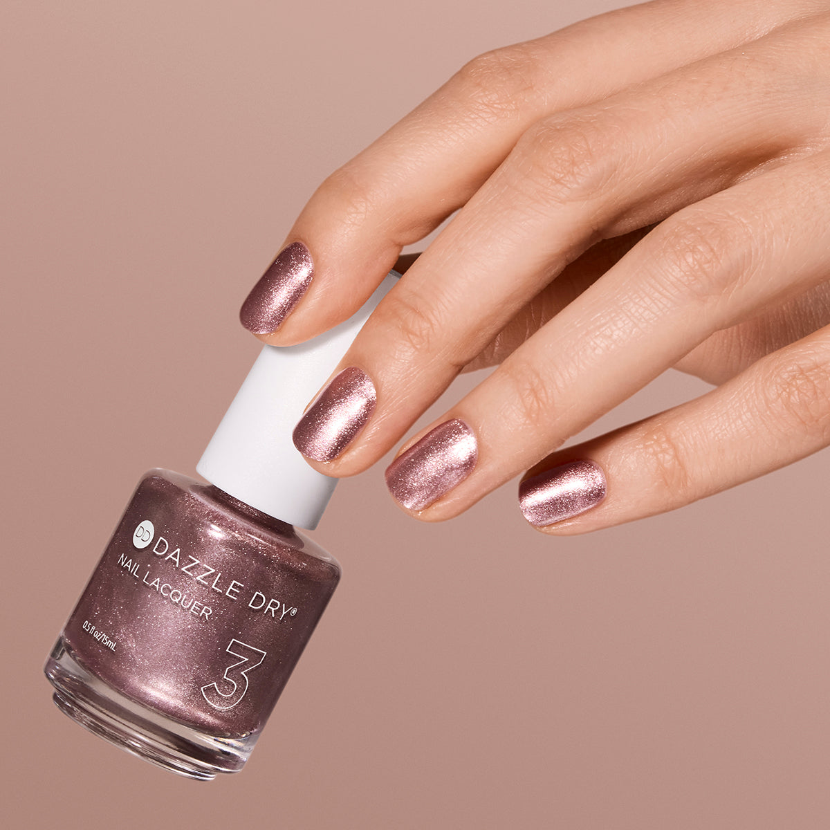 Hand with Out N' About painted on nails holding lacquer bottle