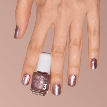 Hand with Out N' About painted on nails holding mini lacquer bottle.