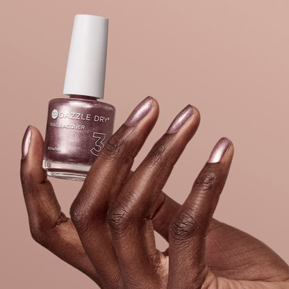 Hand with Out N' About painted on nails holding lacquer bottle