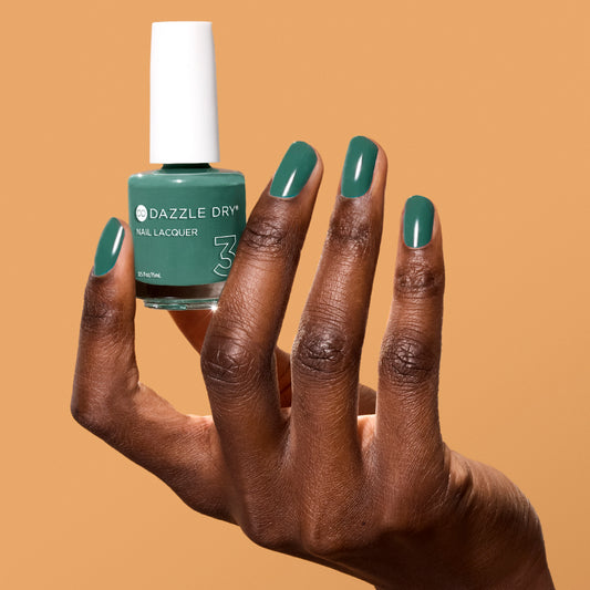 Hand with 3-Day Weekend painted on nails holding full size lacquer bottle