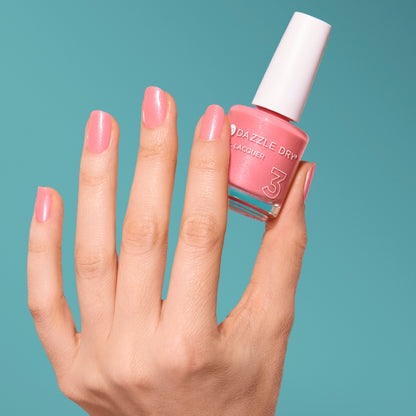 Hand with Cherry Blossom painted on nails holding full size lacquer bottle