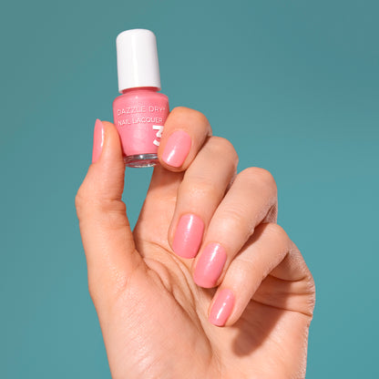 Hand with Cherry Blossom painted on nails holding mini lacquer bottle