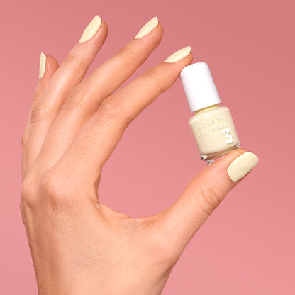 Hand with Sundress painted on nails holding mini  lacquer bottle