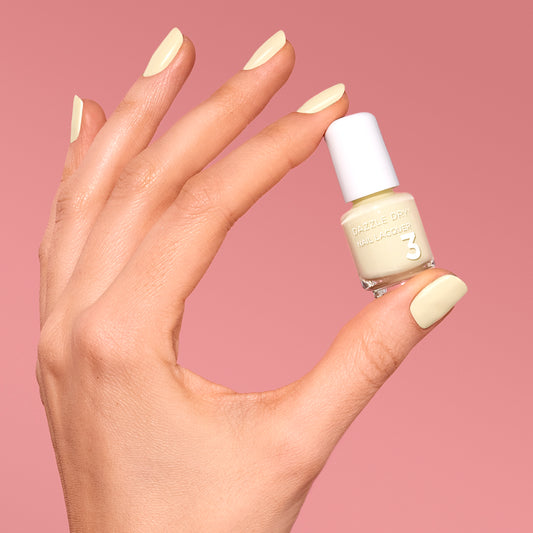 Hand with Sundress painted on nails holding mini  lacquer bottle