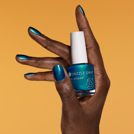 Hand with Speed Boat painted on nails holding lacquer bottle