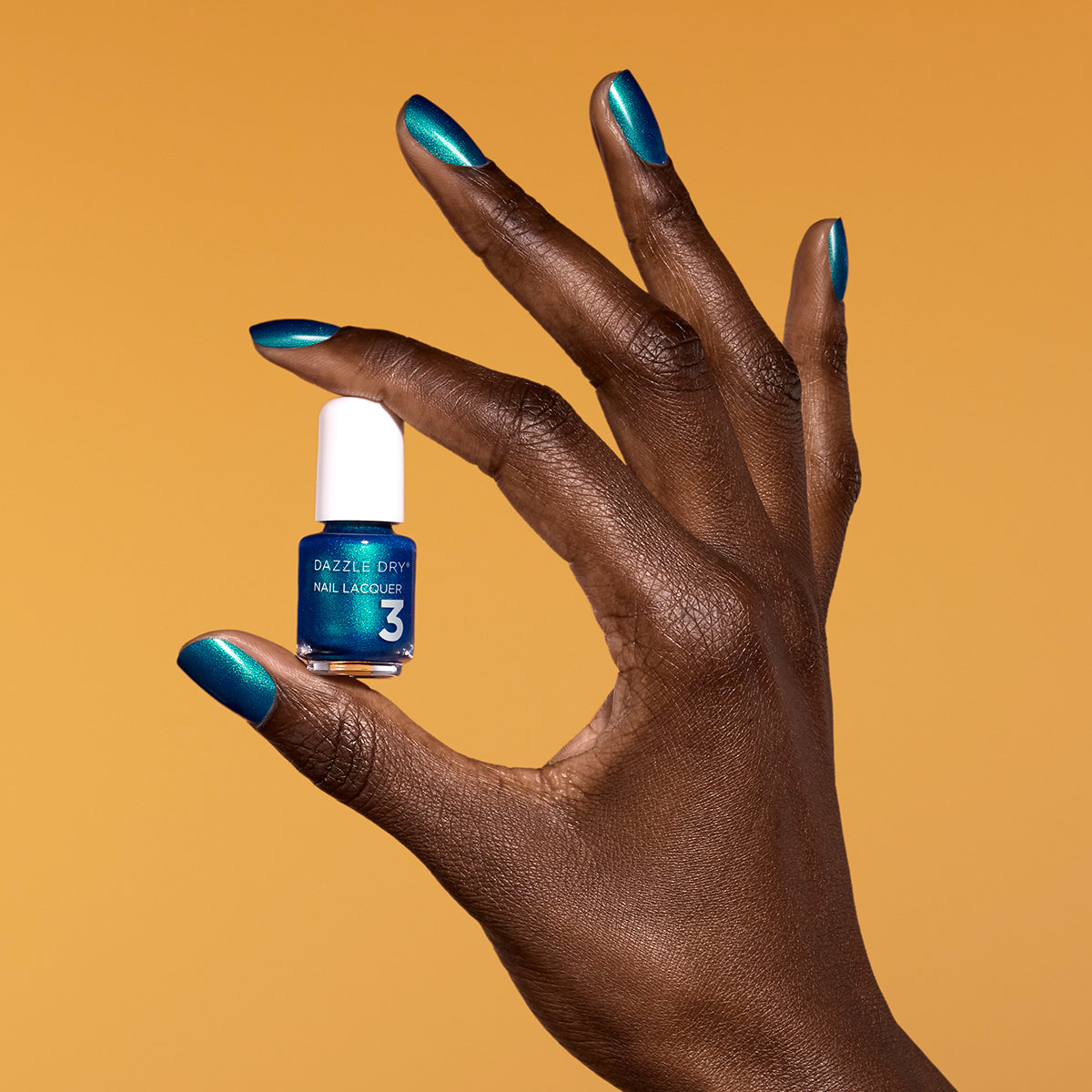 Hand with Speed Boat painted on nails holding mini lacquer bottle