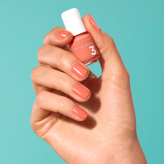 Hand with Round Trip painted on nails holding mini size lacquer bottle