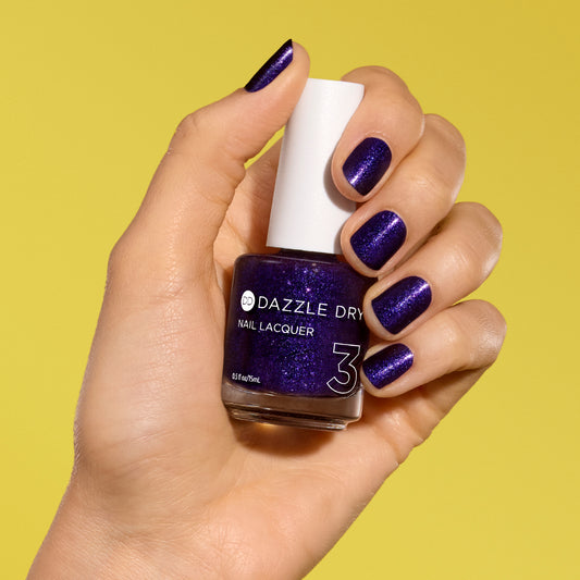 Hand with Fast Lane painted on nails holding lacquer bottle