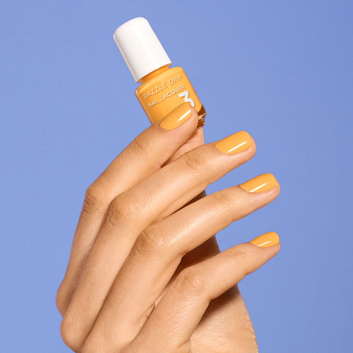 Hand with Go Go Mango painted on nails holding mini nail lacquer bottle