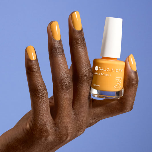 Hand with Go Go Mango painted on nails holding full size lacquer bottle