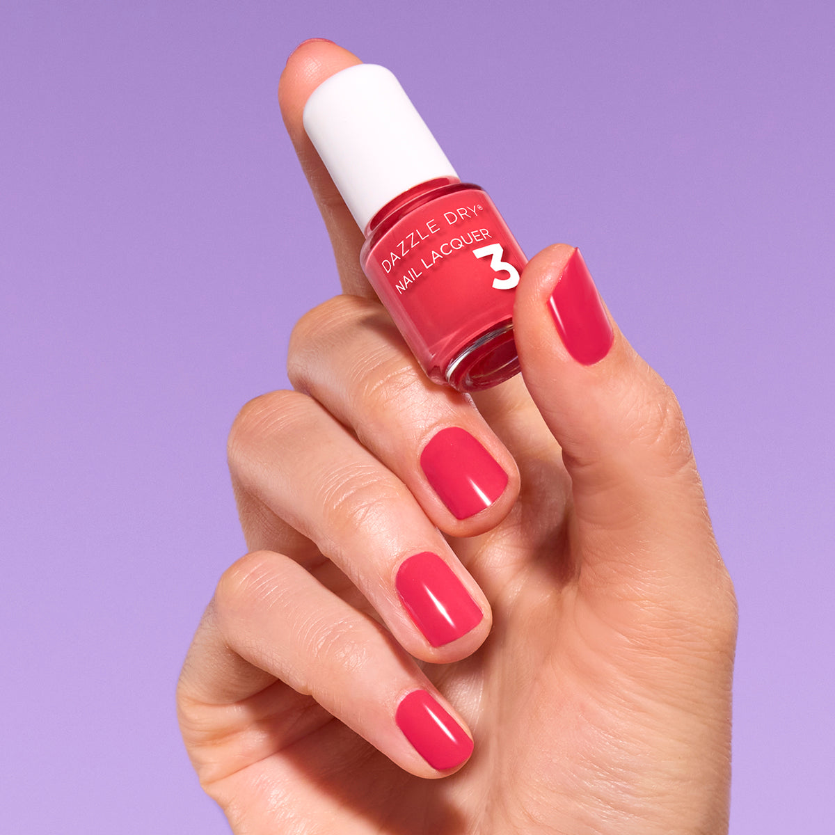 Hand with Let's Get Away painted on nails holding mini size lacquer bottle