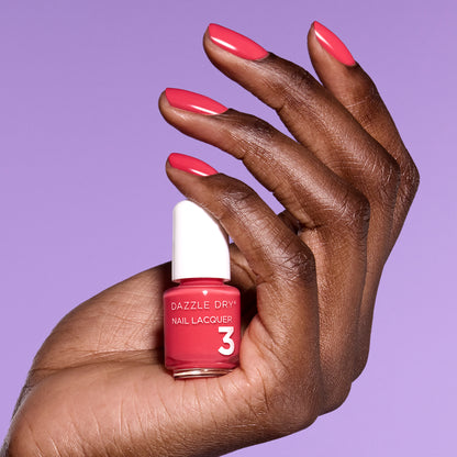 Hand with Let's Get Away painted on nails holding mini size lacquer bottle