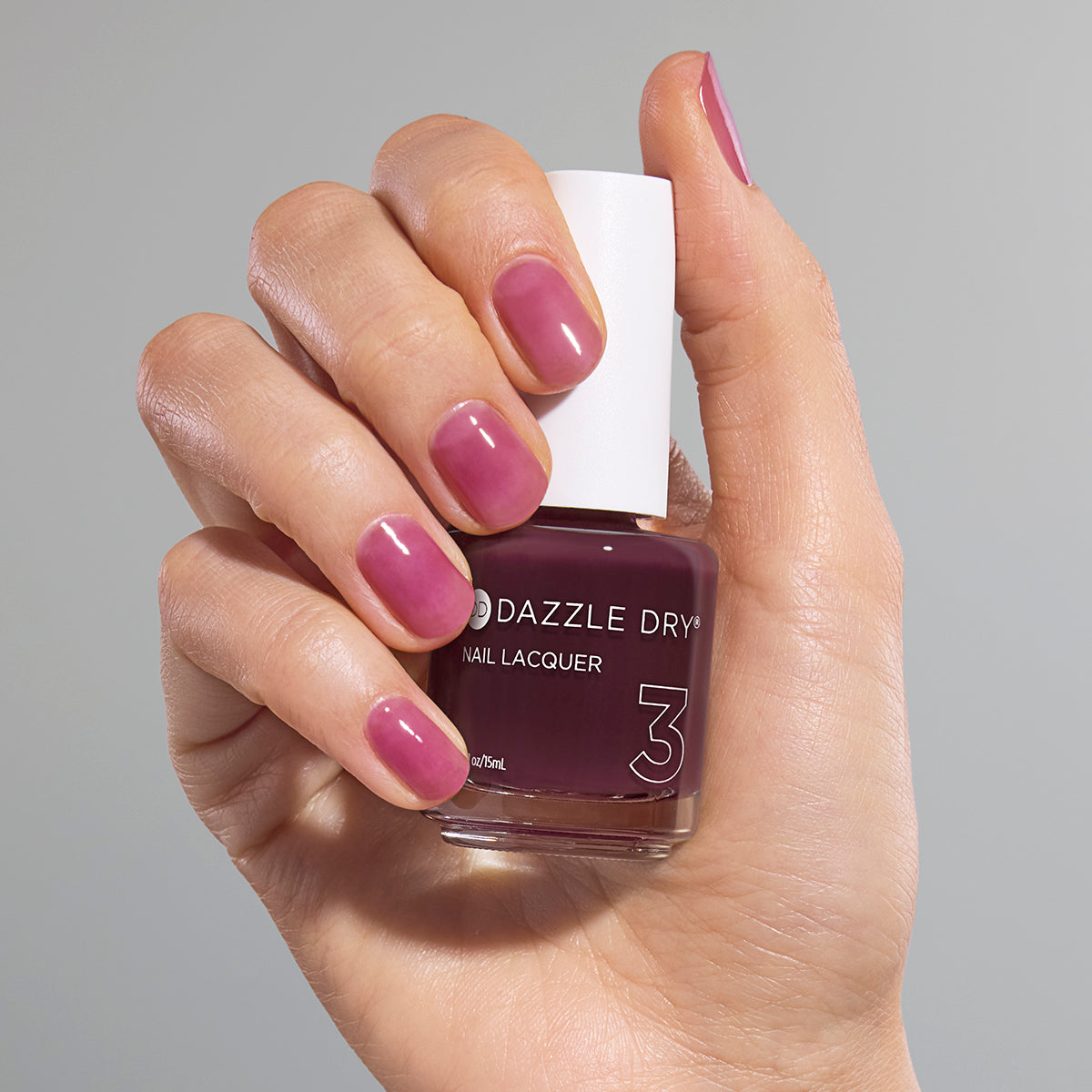 Hand with Tickets Please painted on nails holding full-size lacquer bottle