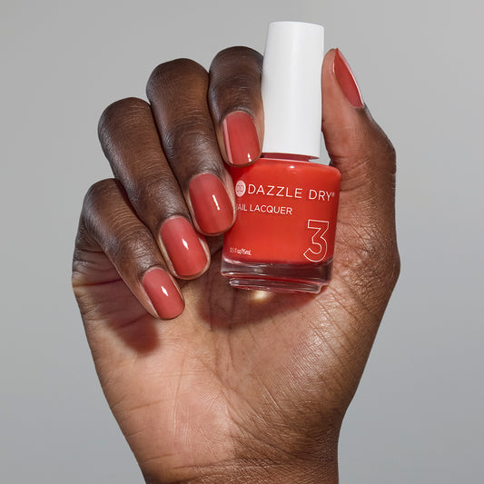 Hand with Sweet and Juicy painted on nails holding full size lacquer bottle