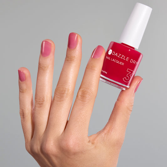 Hand with Sugar Dipped painted on nails holding lacquer bottle