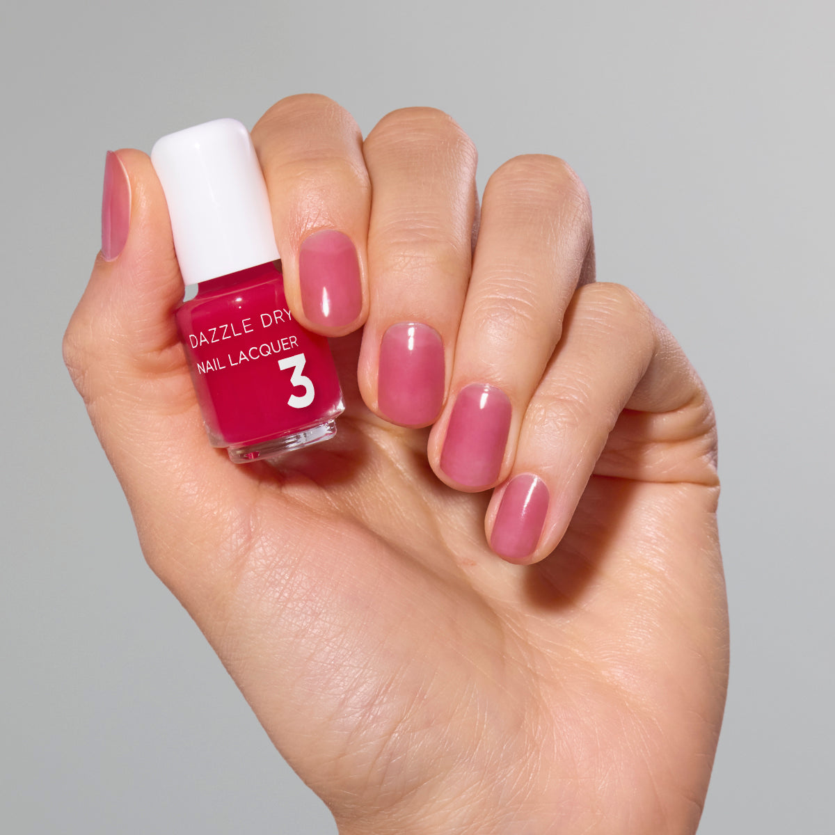 Hand with Sugar Dipped painted on nails holding mini lacquer bottle