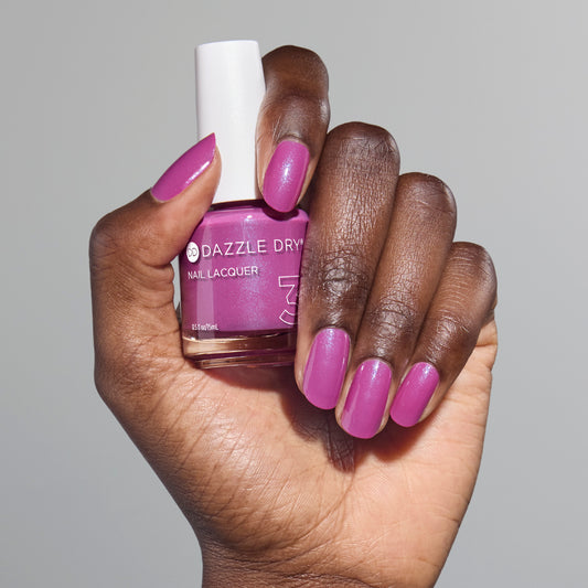 Hand with Mulberry painted on nails holding full size lacquer bottle