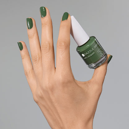 Hand with Fern painted on fingernails holding full size lacquer bottle