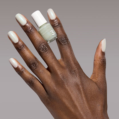 Hand with Embark painted on nails holding mini lacquer bottle