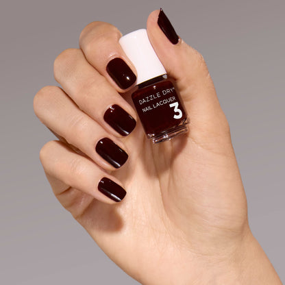 Hand with Mulled Wine painted on nails holding mini nail lacquer