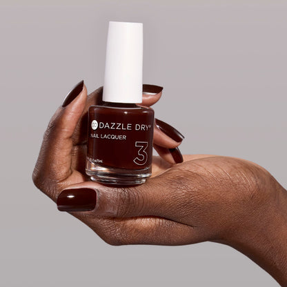 Hand with Mulled Wine painted on nails holding full size nail lacquer