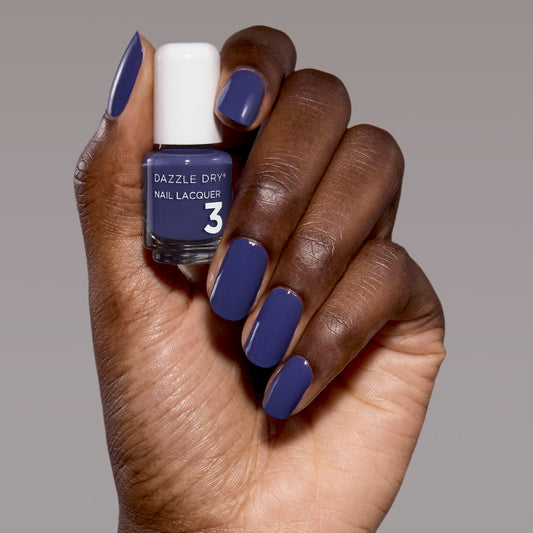 Hand with Base Camp painted on nails holding mini nail lacquer