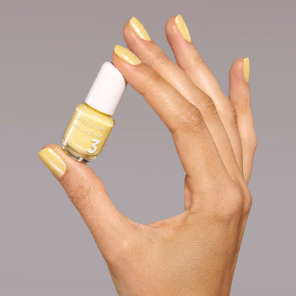 Hand with Solstice painted on nails holding mini lacquer bottle