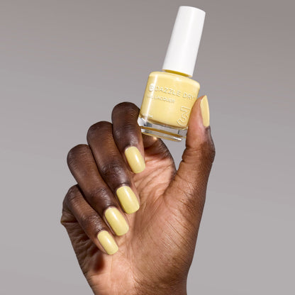 Hand with Solstice painted on nails holding full size lacquer bottle