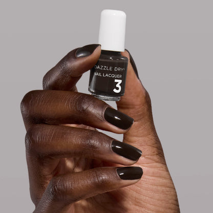 Hand with Haze painted on nails holding mini lacquer bottle