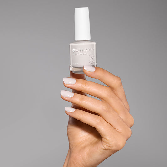 Hand with A Clean Slate painted on nails holding lacquer bottle