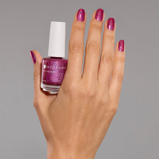 Hand with Beauty Sleep painted on nails holding lacquer bottle