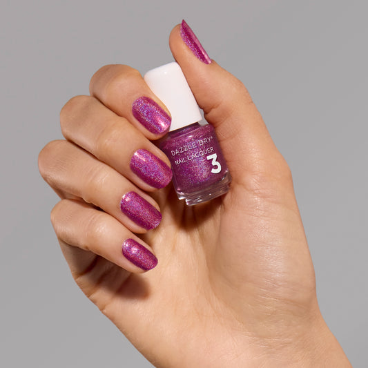 Hand with Beauty Sleep painted on fingernails holding mini nail polish bottle