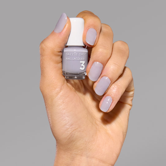 Hand with Fresh Start painted on nails holding mini nail lacquer bottle.